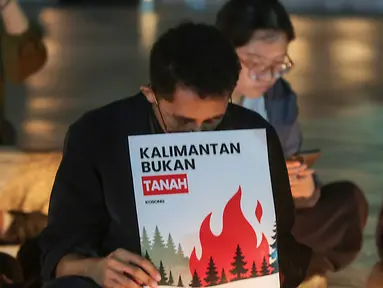 Sejumlah poster yang dibawa simpatisan masyarakat turut mewarnai aksi solidaritas dan doa bersama untuk korban kebakaran hutan dan lahan (karhutla) di Tugu Proklamasi, Jakarta, Senin malam (19/10/2026). (KLY/Budy Santoso)