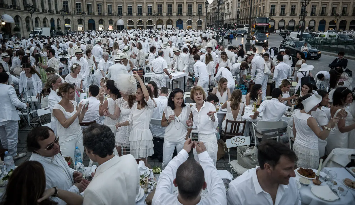 Keseruan peserta saat acara 'Diner en blanc' atau 'Makan Malam Putih' digelar di Place Vendome, Paris, Rabu (8/6). Acara ini digelar secara dadakan serta memanfaatkan teknologi internet dan jejaring sosial sebagai sarana publikasi.  (PHILIPPE LOPE/AFP)