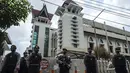 Anggota kepolisian berjaga saat proses penyisiran sebuah gereja di Surabaya menjelang Paskah setelah bom bunuh diri di katedral Makassar, Rabu (31/3/2021). Kegiatan tersebut merupakan upaya peningkatan pengamanan tempat ibadah, khususnya gereja di kota pahlawan. (Juni Kriswanto/AFP)