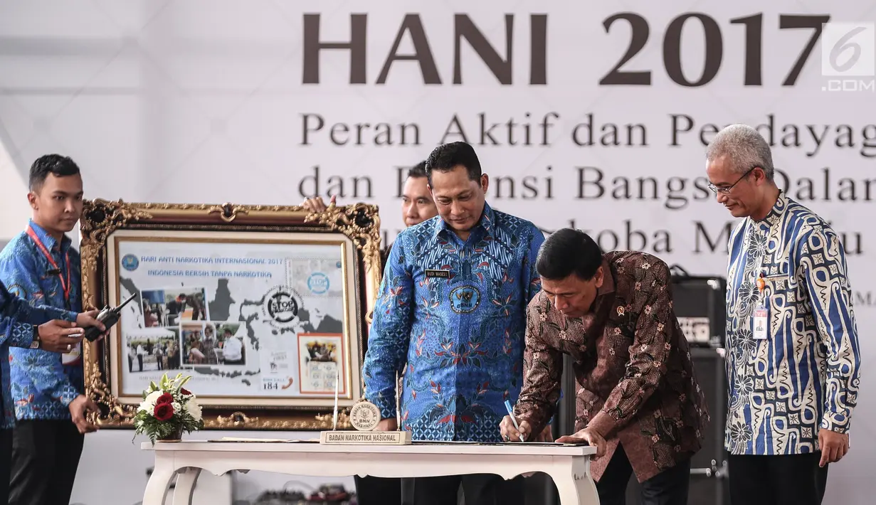 Menko Polhukam Wiranto  menandatangai prangko edisi HANI 2017 dalam puncak peringatan Hari Anti-Narkoba Internasional (HANI) di Plaza Tugu Api Pancasila, Taman Mini Indonesia Indah, Jakarta, Kamis (13/7). (Liputan6.com/Faizal Fanani)