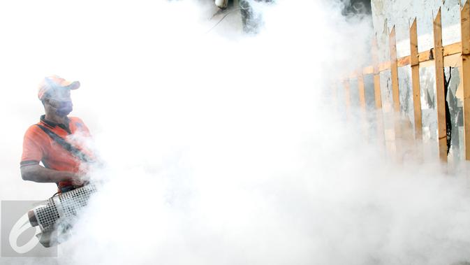 Petugas melakukan penyemprotan asap di salah satu gang di kawasan Menteng Atas dan Menteng Tenggulun, Jakarta, Senin (8/5). Penyemprotan asap dilakukan untuk mencegah perkembangbiakan nyamuk demam berdarah. (Liputan6.com/Helmi Fithriansyah)