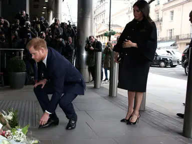 Pangeran Harry dan Meghan Markle meletakkan karangan bunga sebagai penghormatan kepada para korban serangan teror di Christchurch saat mengunjungi Komisi Tinggi Selandia Baru di London, Selasa (19/3). (Ian Vogler/Pool via REUTERS)