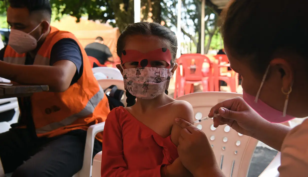 Petugas kesehatan menyuntik vaksin covid-19 kepada seorang anak di San Lorenzo, Paraguay, Senin (31/1/2022). Paraguay mulai memvaksinasi anak-anak berusia 5 hingga 11 tahun pada hari Senin, karena peningkatan tajam infeksi covid-19 yang didorong oleh varian omicron. (NORBERTO DUARTE / AFP)
