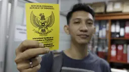 Seorang wartawan menunjukan sertifikat vaksin usai disuntik polio jelang SEA Games 2019 di Kantor Kemenpora, Jakarta, Rabu (13/11). Suntik vaksin tersebut untuk mengantisipasi wabah polio di Filipina. (Bola.com/M Iqbal Ichsan)
