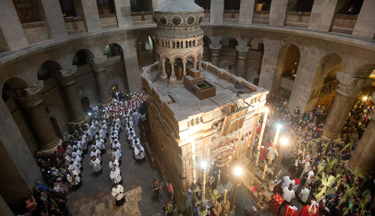 Pendeta Katolik Roma membawa daun palem selama prosesi Minggu Palma di Gereja Makam Kudus, Kota Tua Yerusalem, Minggu (25/3). Minggu Palma dirayakan setiap menjelang Paskah. (AP Photo/Oded Balilty)
