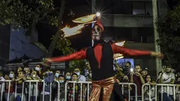Warga menyaksikan parade Mitos dan Legenda di Medellin, Kolombia (8/12/2021). Kolombia memiliki cerita rakyat tradisional dan cerita tentang makhluk legendaris, yang ditransmisikan secara lisan dan diteruskan ke generasi baru. (AFP/Joaquin Sarmiento)
