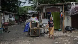 Warga berjalan di permukiman liar di kawasan Bypass, Pramuka, Jakarta Timur, Rabu (21/2). Rencana Pemprov DKI untuk membangun kantor pemadam kebakaran di lokasi tersebut terkendala oleh bangunan liar yang diduduki pemulung. (Liputan6.com/Faizal Fanani)