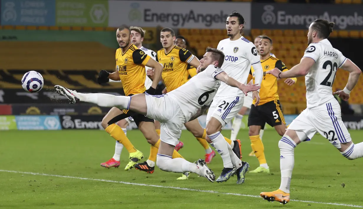Bek Leeds United, Liam Cooper (kiri) melepaskan tendangan di mulut gawang Wolverhampton Wanderers dalam laga Lanjutan Liga Inggris 2020/21 pekan ke-25 di Molineux Stadium, Jumat (19/2/2021). Leeds kalah 0-1 dari Wolverhampton. (AP/Catherine Ivill/Pool)