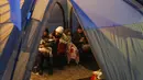 Wanita dan anak-anak beristirahat dalam tenda setelah tiba di perbatasan di Medyka, Polandia, Sabtu (5/3/2022). Mereka melarikan diri dari invasi Rusia di Ukraina. (AP Photo/Markus Schreiber)