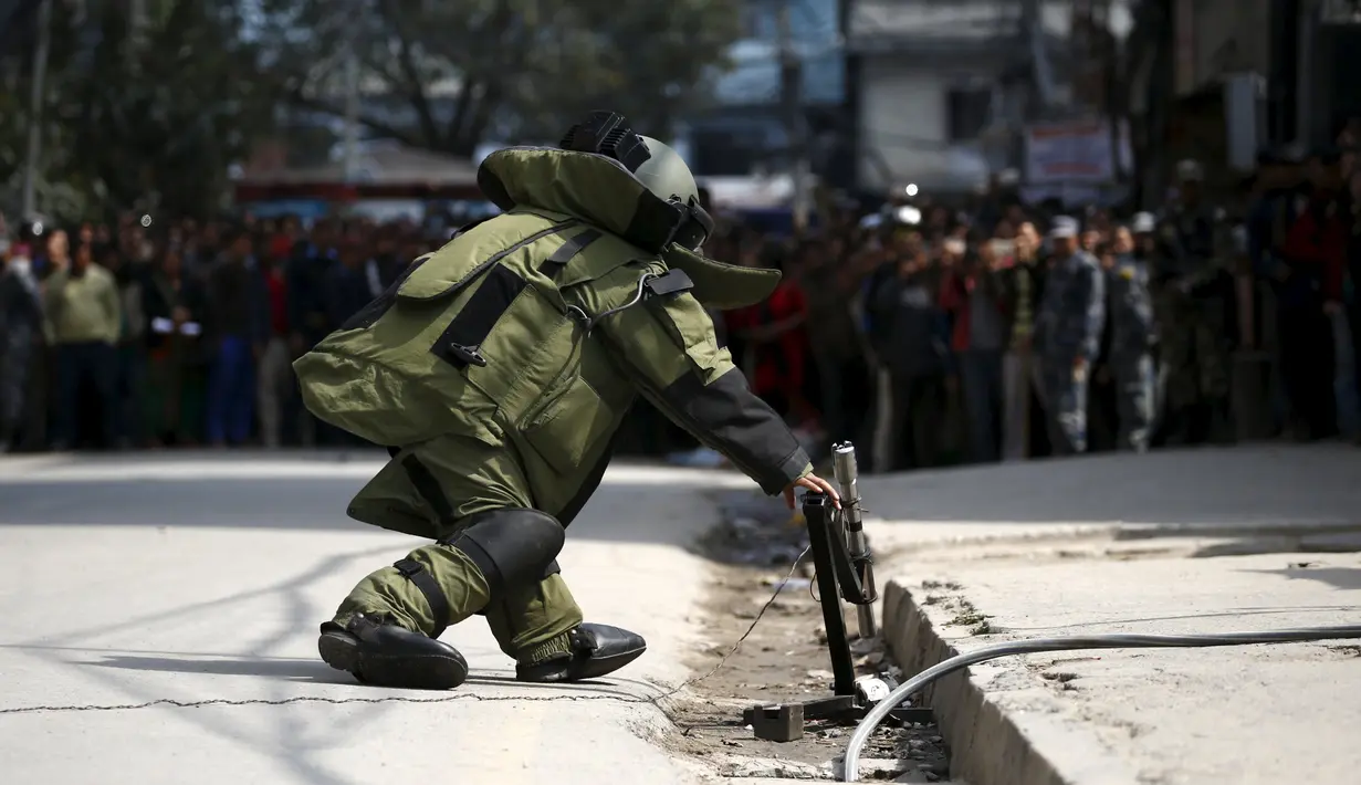 Seorang anggota tim penjinak bom saat akan mengamankan sebuah benda mencurigakan dipinggir jalan kompleks kantor Singha Durbar, Nepal, (1/3).Setelah diselidiki benda itu hanyalah sebuah alarm biasa. (REUTERS / Navesh Chitrakar)