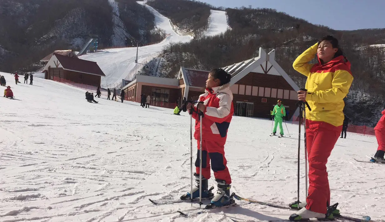 Seorang ibu dan putrinya beristirahat di lereng di resor ski Masik Pass di Korea Utara (28/1). Resor ski ini juga sebagai tempat latihan tim ski Korea Utara dan Korea Selatan menjelang Olimpiade Pyeongchang 2018. (AP Photo / Eric Talmadge)