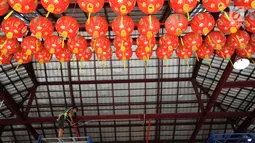 Seorang pria memasang lampion di Vihara Kwan In Thang Pondok Cabe, Tangerang Selatan, Banten, senin (28/1). Sepekan menjelang perayaan Tahun Baru China atau Imlek sejumlah vihara terus berbenah untuk mempercantik Vihara. (Merdeka.com/Arie Basuki)