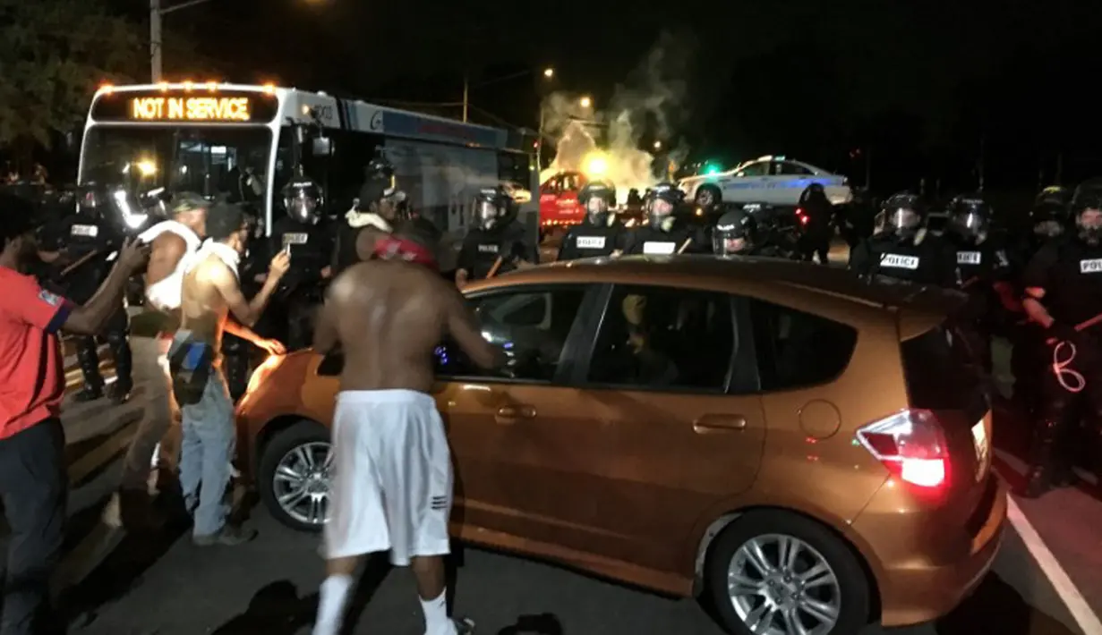 Aksi protes penembakan pria kulit hitam di AS berujung bentrok, AS, Selasa (20/9). Bentrokan tak terhindarkan saat polisi menggunakan gas air mata untuk membubarkan massa yang marah. (REUTERS/Adam Rhew)