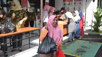 Seorang warga nampak bungah mendapatkan paket bazar sembako murah Adhiyaksa Garut seharga Rp 100 ribu per paket. (Liputan6.com/Jayadi Supriadin)