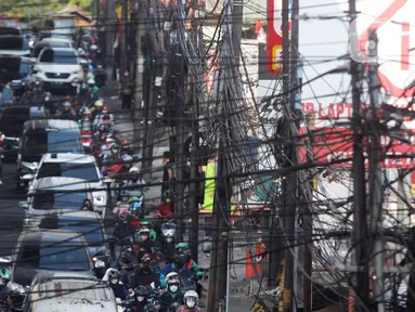 Kabel utilitas semrawut melintang di atas Jalan Ciledug Raya, Kawasan Seskoal, Kebayoran Lama, Jakarta, Selasa (8/8/2023). (Liputan6.com/Johan Tallo)