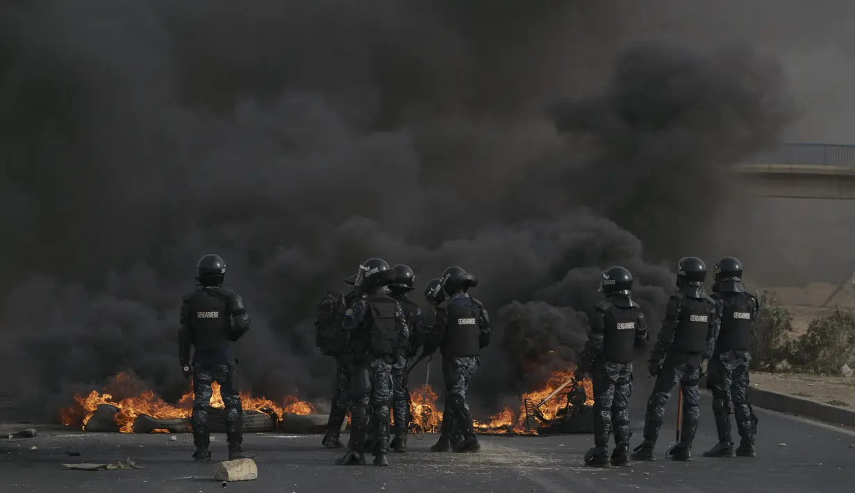 Polisi menembakkan gas air mata dan para demonstran membakar mobil-mobil pada hari Senin di dekat rumah pemimpin oposisi utama Senegal.  (AP Photo/Leo Correa)