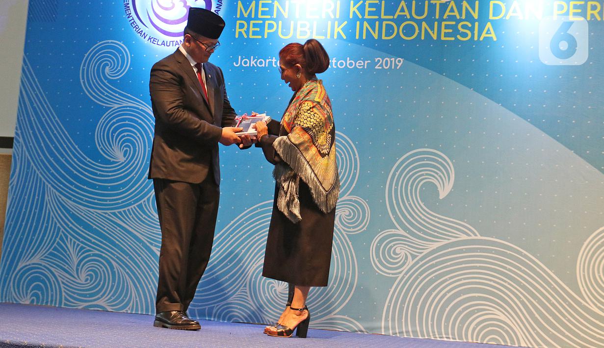 Susi Pudjiastuti memberikan buku kepada Edhy Prabowo dalam acara serah terima jabatan (Sertijab) Menteri Kelautan dan Perikanan di Kantor KKP, Jakarta, Rabu (23/10/2019). Edhy menggantikan Susi Pudjiastuti pada Kabinet Indonesia Maju periode 2019-2024. (Liputan6.com/Herman Zakharia)