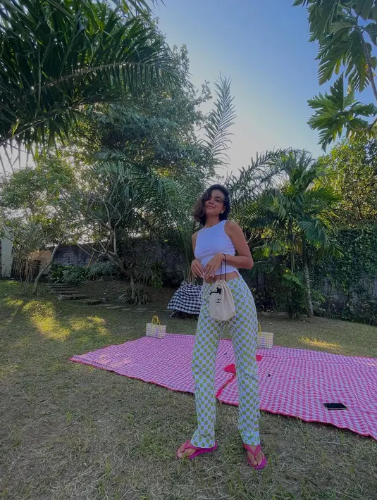 Beri gaya klasik crop top putih dengan celana bermotif cerah khas summer (Foto: Instagram @evacelia)