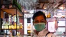 Bartender Gagan membersihkan bar jelang pembukaan kembali di New Delhi, 8 September 2020. Setelah sebelumnya ditutup karena pandemi COVID-19, mulai 9 September 2020 New Delhi mengizinkan bar kembali buka dengan kapasitas tempat duduk 50 persen. (Prakash SINGH/AFP)