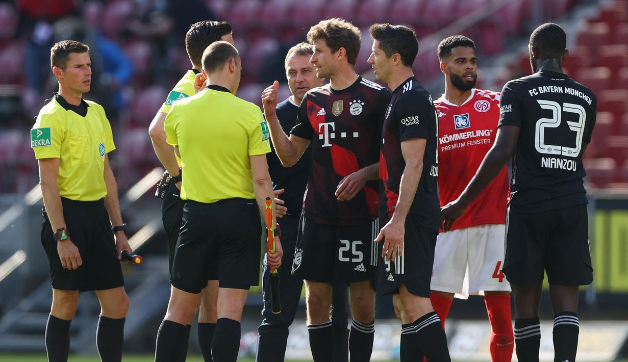 Dua striker Bayern Munich, Thomas Mueller dan Robert Lewandowski berdebat dengan wasit dan asistennya usai berakhirnya laga lanjutan Liga Jerman 2020/2021 pekan ke-31 melawan FSV Mainz di Opel Arena, Mainz, Sabtu (24/4/2021). Bayern Munich kalah 1-2 dari FSV Mainz. (AFP/Kai Pfaffenbach/Pool)
