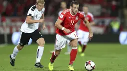 Pemain Wales, Gareth Bale melewati adangan pemain Austria pada laga Group D kualifikasi Piala Dunia 2018 di Cardiff City Stadium, Cardiff, (2/8/2017). Wales menang 1-0. (David Davies/PA via AP)