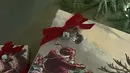 Sedangkan Kylie memilih bungkus kado bergambarkan kereta Santa dengan aksen pita yang menggemaskan.  [Foto: Instagram/ Kim Kardashian]