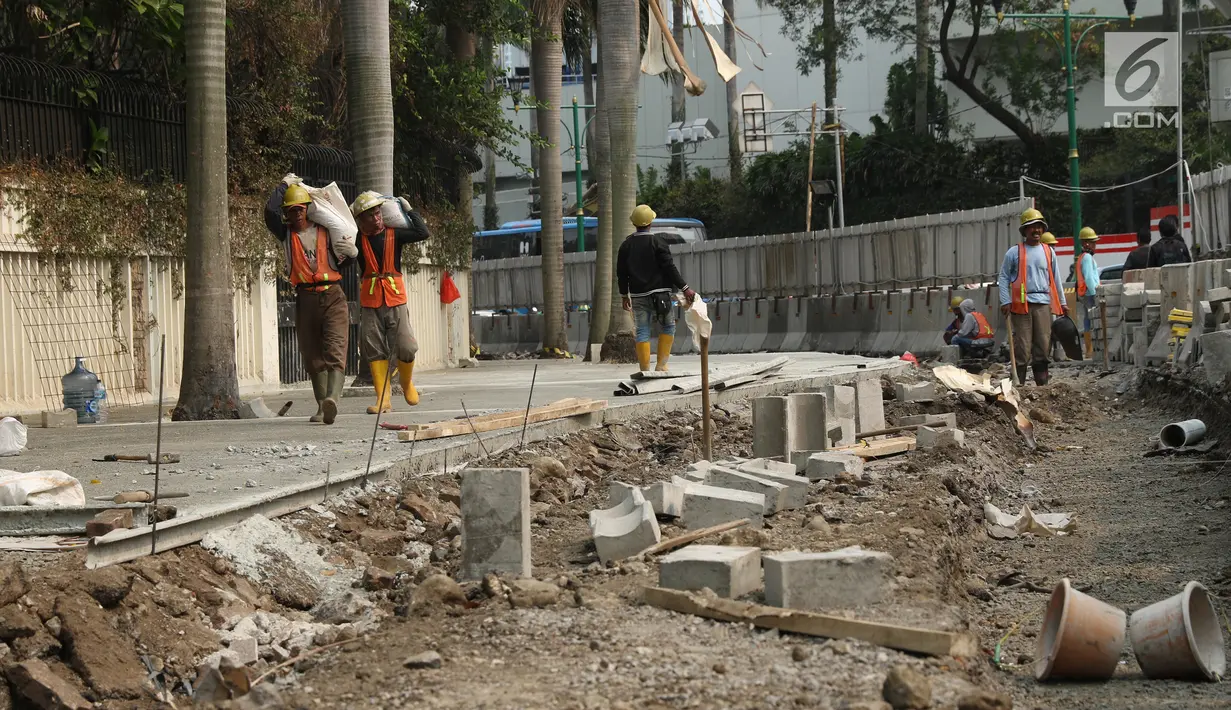 Pekerja menyelesaikan proyek revitalisasi trotoar di kawasan Bundaran Hotel Indonesia, Jakarta, Selasa (24/9/2019). Pemerintah Provinsi (Pemprov) DKI tengah mengebut pembangunan revitalisasi trotoar di sejumlah titik Ibu Kota yang ditargetkan rampung akhir 2019 mendatang. (Liputan6.com/Angga Yuniar)