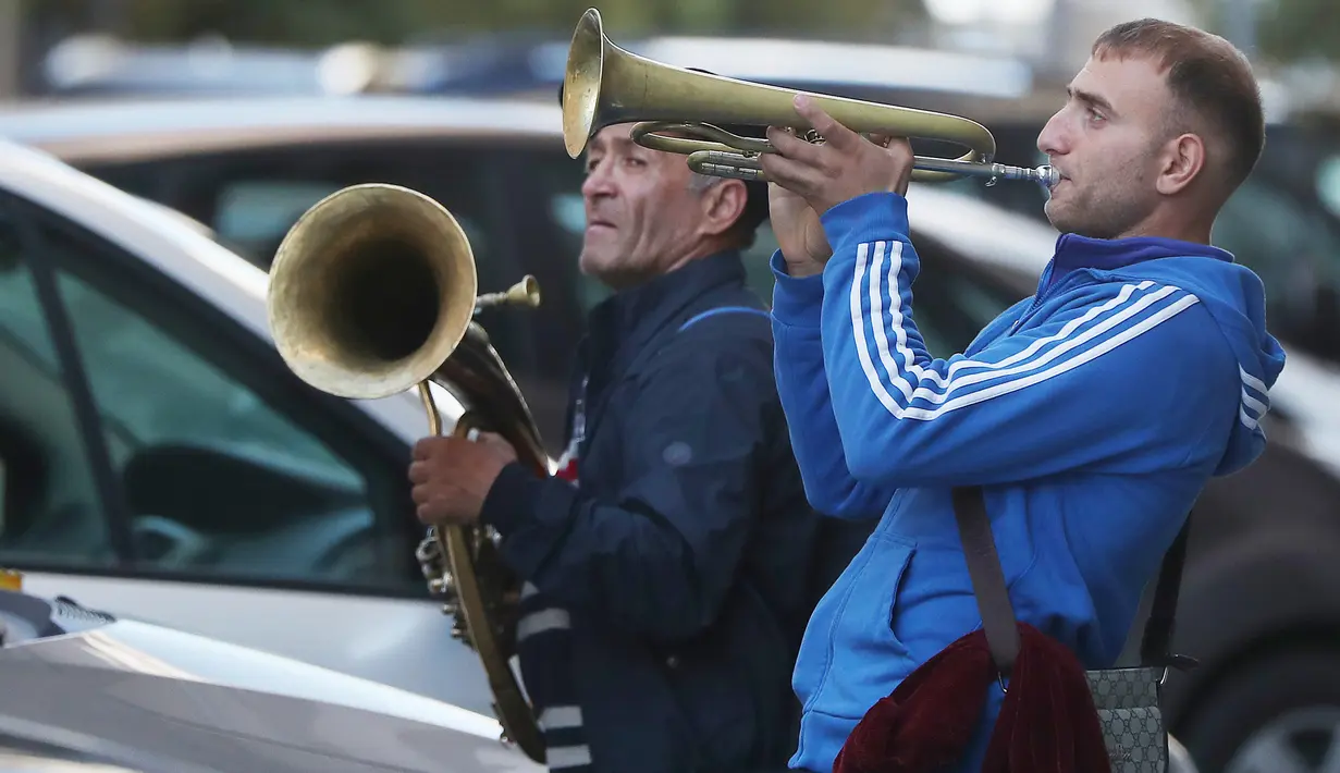 Aksi orkes tiup musisi Rumania untuk mendapat uang di jalanan Warsawa, Polandia pada 21 Oktober 2019. Orkes tiup yaitu sekelompok orang yang memperagakan musik dengan menggunakan instrumen musik tiup baik tiup logam maupun tiup kayu.  (AP Photo/Czarek Sokolowski)