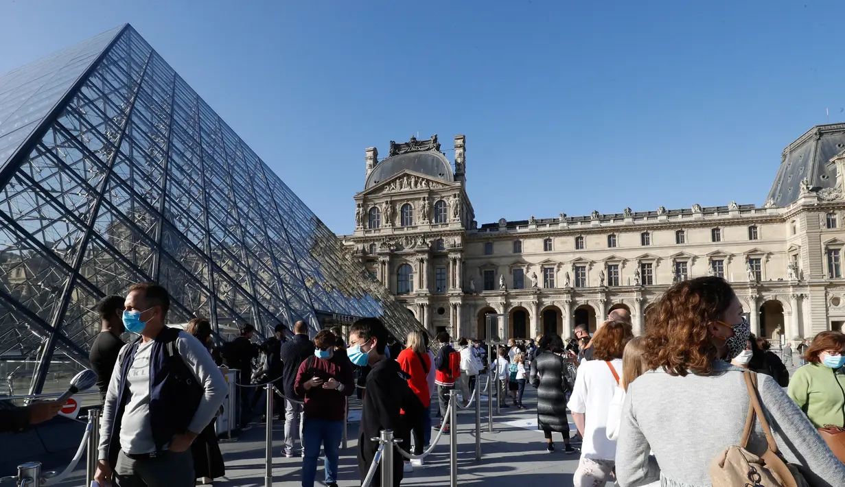 Pengunjung mengentre di piramida Louvre yang dirancang arsitek China Ieoh Ming Pei, pintu masuk ke Museum Louvre pada hari pertama pembukaan di Paris (6/7/2020). Setelah berbulan-bulan ditutup akibat lockdown Covid-19, Museum Louvre  kembali dibuka pada 6 Juli 2020. (AFP/Francois Guillot)