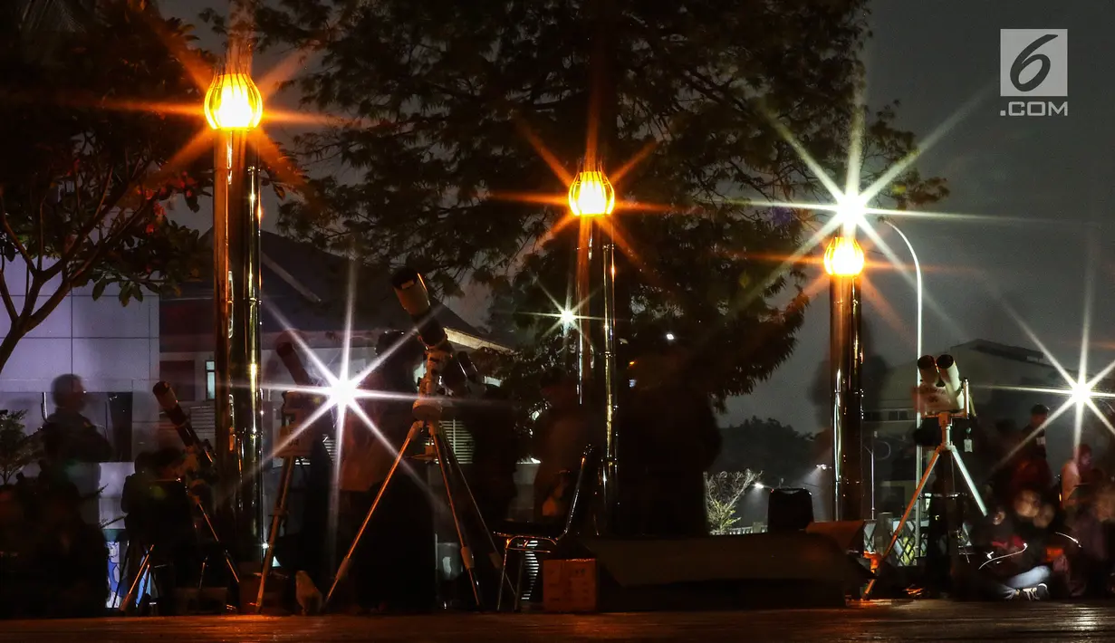 Warga menggunakan teleskop untuk melihat gerhana bulan sebagian (parsial) di Taman Ismail Marzuki, Jakarta, Rabu (17/7/2019) dini hari. Gerhana bulan terakhir dalam tahun 2019 ini merupakan fenomena jenis gerhana bulan parsial, karena masih ada yang tampak sebagian. (Liputan6.com/Johan Tallo)