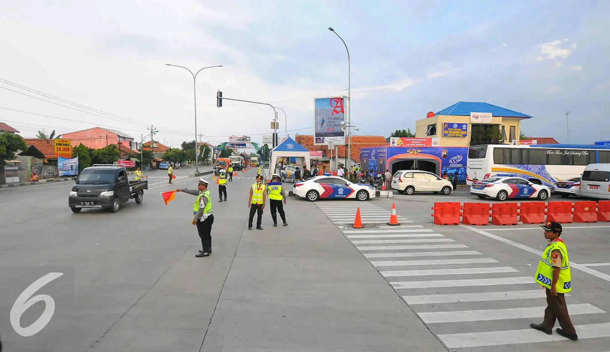 Anggota Pramuka membantu Polisi mengatur lalu lintas di pertigaan pintu keluar tol Brebes, Jawa Tengah, Jumat (23/12). Selain polisi, sejumlah relawan dari anggota Pramuka ikut membantu kelancaran arus mudik Natal 2016. (Liputan6.com/Angga Yuniar)