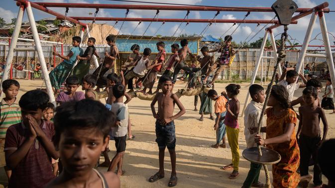 Anak-anak pengungsi Rohingya bermain ayunan di taman bermain di kamp pengungsi Thangkhali, dekat Cox's Bazar, Bangladesh, Kamis (9/8). (Ed JONES/AFP)