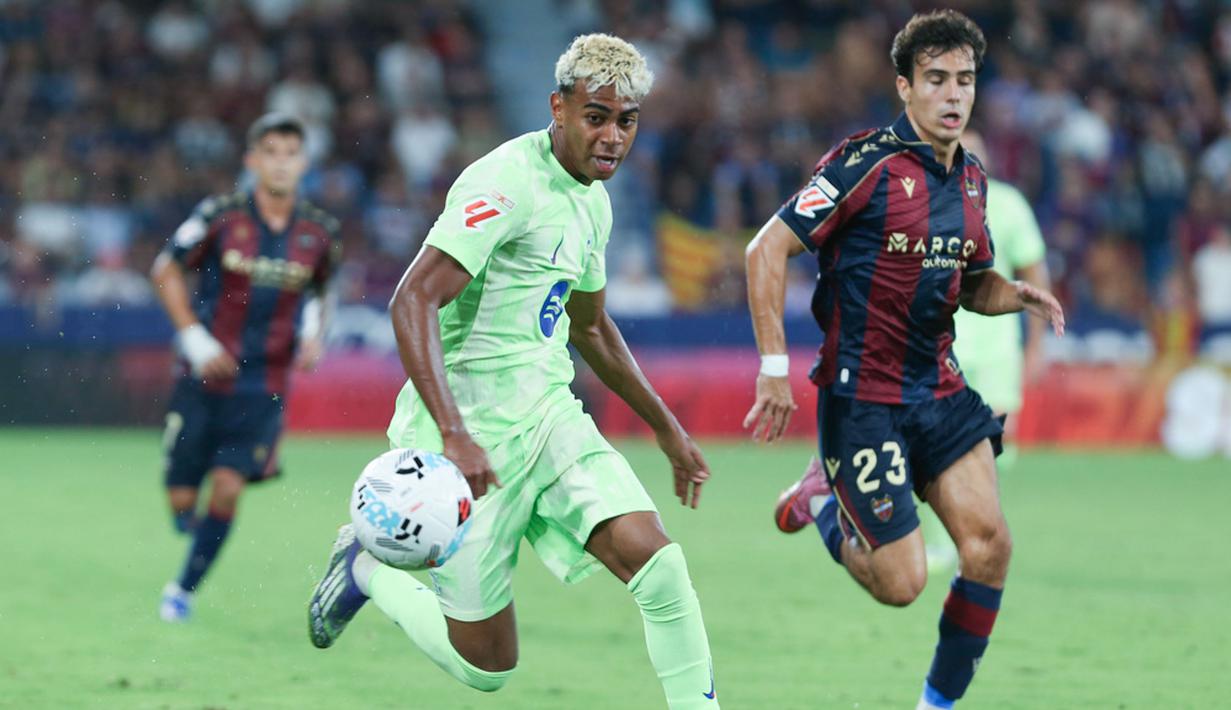Pemain Barcelona, Lamine Yamal, berusaha melewati pemain Levante pada jornada kedua La Liga 2025/2026 di Estadio Ciudad de Valencia, Minggu (24/8/2025) dini hari WIB. (AP Photo/Alberto Saiz)
