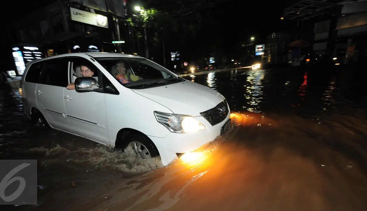 Kendaraan roda empat melintasi jalanan yang tergenang banjir di kawasan Kemang, Jakarta, Minggu (25/9). Hujan deras yang mengguyur sebagian besar kawasan di Jakarta, Minggu malam, membuat wilayah Kemang terendam banjir lagi. (Liputan6.com/Helmi Afandi)