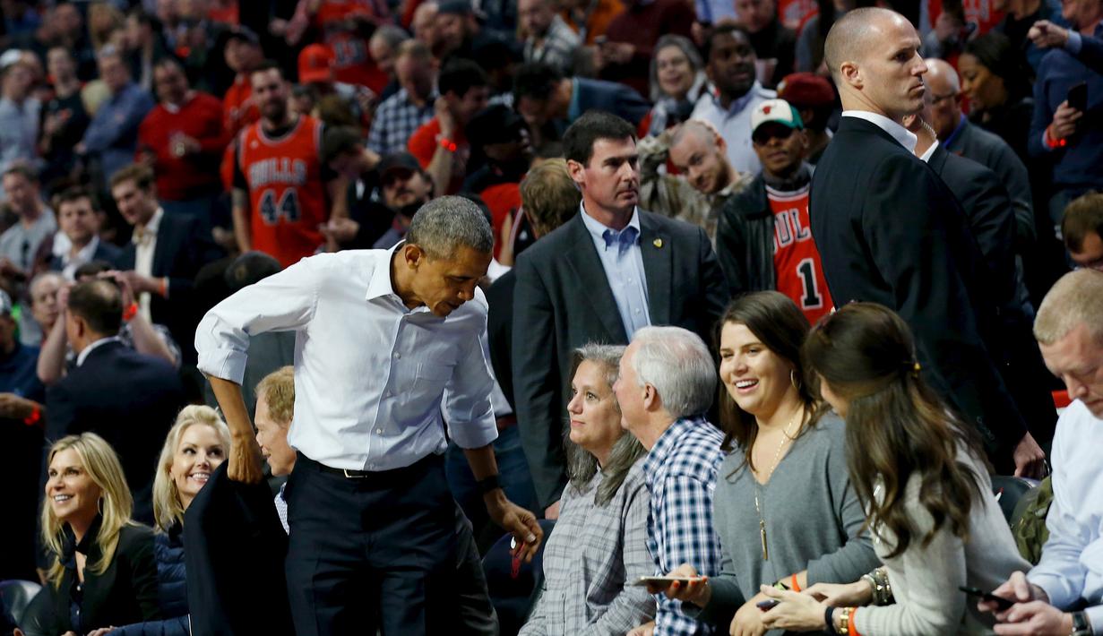 President Amerika Serikat Barack Obama melepas jas saat menyaksikan pembukaan NBA antara  Cleveland Cavaliers melawan Chicago Bulls di Chicago, Selasa(27/10/2015). (REUTERS / Jonathan Ernst)