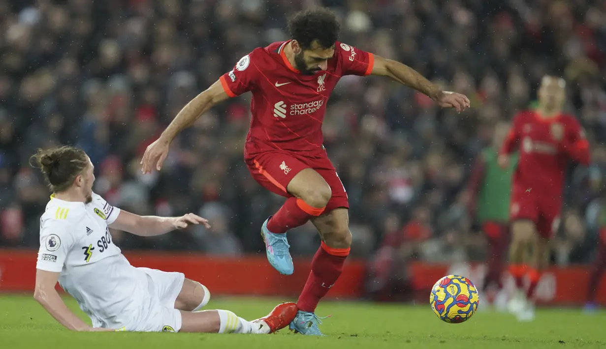 Penyerang Liverpool,Mohamed Salah berusaha melewati pemain Leeds United, Luke Ayling selama pertandingan lanjutan Liga Inggris di stadion Anfield di Liverpool, Inggris, Kamis (24/2/2022). Liverpool menang telak atas Leeds United 6-0.  (AP Photo/Jon Super)