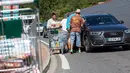 Petani membagikan produk yang diambil dari supermarket Casino kepada pengendara yang lewat di Sarlat, Perancis barat daya, sebagai bentuk demo di supermarket tersebut, Kamis (20/8/2015). (AFP PHOTO/Yohan Bonnet)