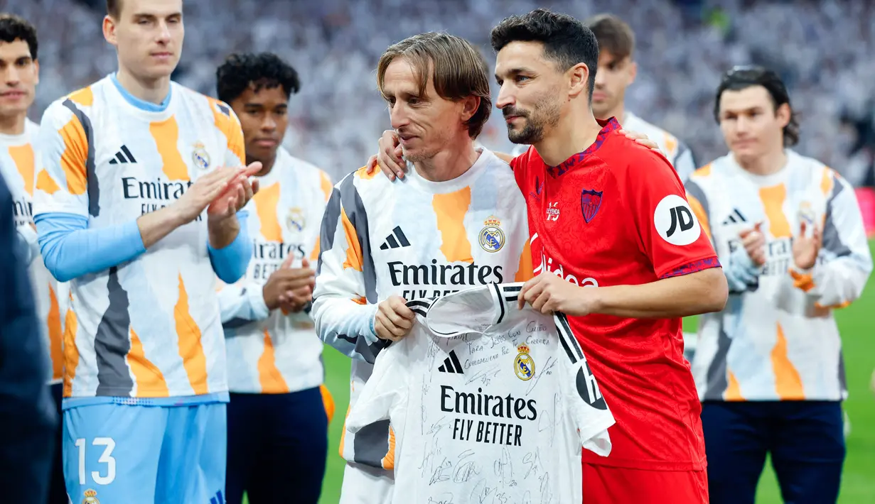Dalam kesempatan yang hangat itu, Luka Modric, salah satu pemain Real Madrid, memberikan jersey Madrid yang telah ditandatangani oleh seluruh skuad kepada Navas. (AFP/Oscar Del Pozo)