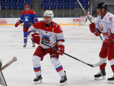 Presiden Rusia Vladimir Putin (kiri) dan Presiden Belarus Alexander Lukashenko (kanan) ikut serta dalam pertandingan hoki es di Shayba Arena, Resor Laut Hitam Sochi, Rusia, (15/2). (Sergei Chirikov / Pool / AFP)