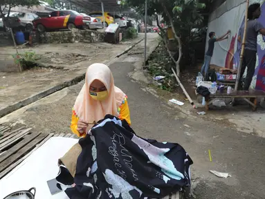 Warga menyelesaikan pembuatan batik tulis saat pelaksanaan kegiatan mural Raincity Strike #8 di Kampung Batik Cibuluh, Bogor, Minggu (22/11/2020). Kegiatan seni mural ini melibatkan puluhan seniman mural se-Jabodetabek di kampung batik. (merdeka.com/Arie Basuki)