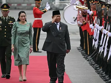 Perdana Menteri Thailand Paetongtarn Shinawatra (tengah) bersama Presiden Republik Indonesia Prabowo Subianto memeriksa barisan kehormatan selama upacara penyambutan di Government House, Bangkok pada 19 Mei 2025. (Lillian SUWANRUMPHA/AFP)