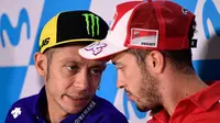 Pembalap tim Yamaha, Valentino Rossi dan pembalap tim Ducati, Andrea Dovizioso berbincang saat konferensi pers MotoGP Aragon 2017 di Sirkuit MotorLand, Kamis (21/9). Rossi dipastikan kembali bertarung di lintasan pada MotoGP Aragon. (JAVIER SORIANO/AFP)