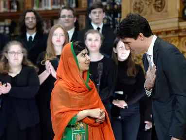 PM Kanada Justin Trudeau memberikan salam kepada aktivis muda pemenang Penghargaan Nobel Perdamaian, Malala Yousafzai pada upacara pemberian hadiah kewarganegaraan di Gedung Parlemen Kanada di Ottawa, Rabu (12/4). (Justin Tang/The Canadian Press via AP)