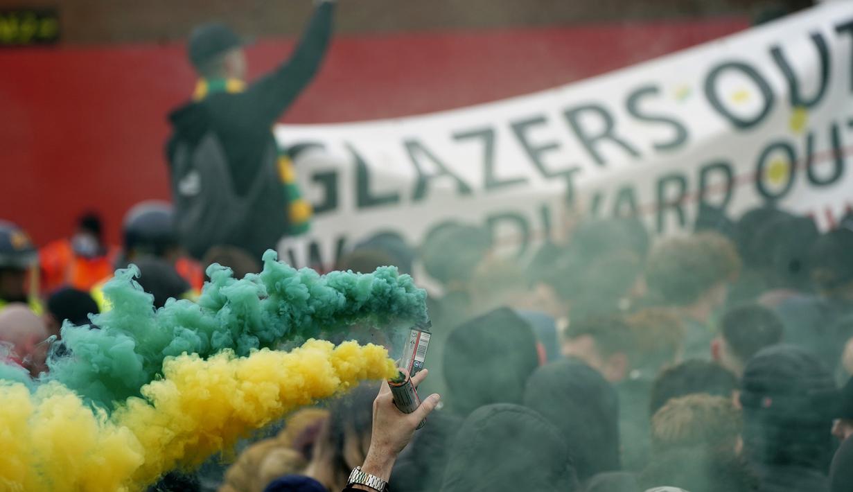 Para pendukung Manchester United melakukan demonstrasi menentang Keluarga Glazer, pemilik sebagian besar saham Manchester United di luar Stadion Old Trafford sebelum laga lanjutan Liga Inggris 2020/2021 pekan ke-35 melawan Liverpool, Kamis (13/5/2021). (AP/Jon Super/Pool)