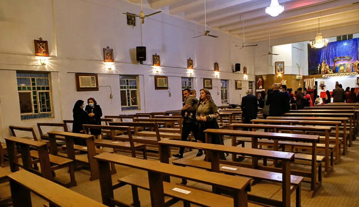 Umat Kristiani menghadiri misa pada malam Natal di Gereja Bapa Suci, Basra, Irak, Kamis (24/12/2020). Natal tahun ini dirayakan oleh umat Kristiani dunia di tengah pandemi COVID-19. (AP Photo/Nabil al-Jurani)