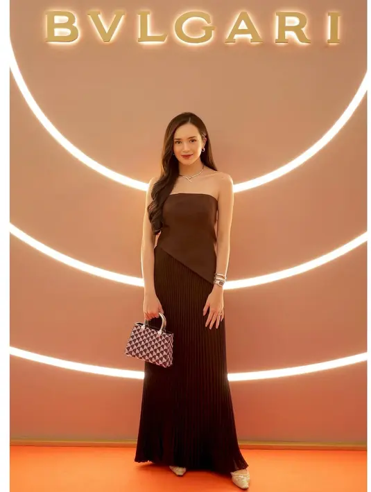 Ia nampak kenakan strapless asymetrical top dengan pleated long skirt dan flatshoes. Ia pun juga terlihat menjinjing tas Bvlgari Serpentine Duo Top Handle seharga Rp126jutaan [@bebytsabina]