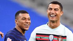 Striker Portugal, Cristiano Ronaldo, tertawa bersama striker Prancis, Kylian Mbappe, pada laga UEFA Nations League di Stadion Stade de France, Senin (12/10/2020). Kedua tim bermain imbang 0-0. (AFP/Franck Fife)