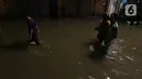 Warga sedang berjalan di tengah banjir yang melanda Jalan Bangka, Jakarta, Rabu (4/1/2023). Hujan deras yang terjadi pada Rabu sore membuat Kali Mampang meluap hingga menyebabkan banjir di kawasan tersebut dengan ketinggian bervariasi mulai dari 40 hingga 60 cm. (Liputan6.com/Herman Zakharia)