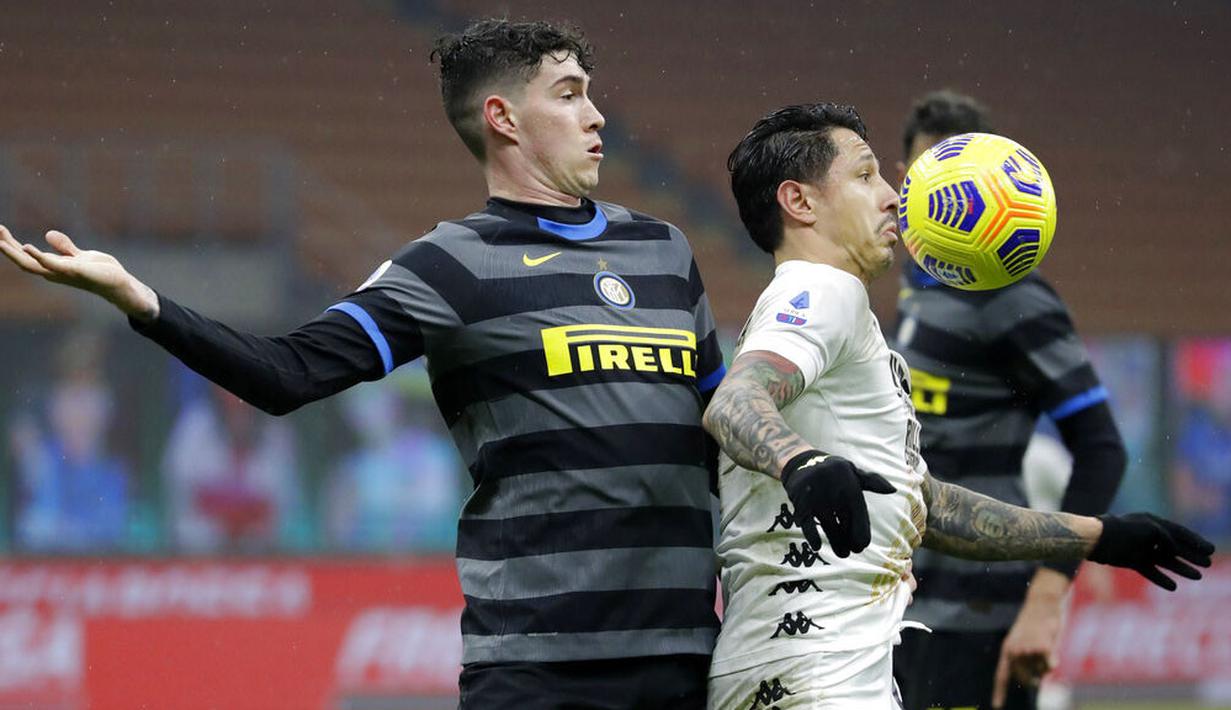 Bek Inter Milan, Alessandro Bastoni, berebut bola dengan pemain Benevento, Gianluca Lapadula, pada laga Liga Italia di Stadion Giuseppe Meazza, Minggu (31/1/2021), Inter Milan menang dengan skor 4-0. (AP/Luca Bruno)
