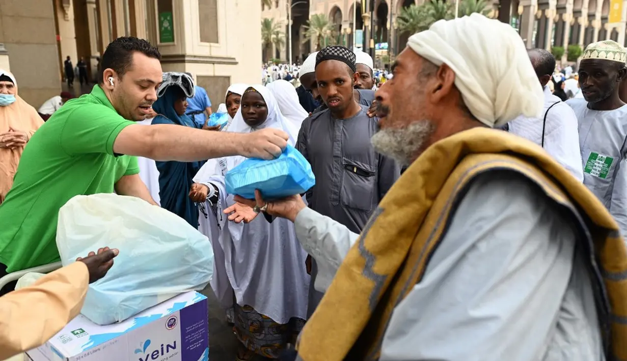 <p>Apalagi pada musim haji, para pemburu pahala ini berhenti di pinggir-pinggir jalan dan membagikan makanan yang mereka punya kepada para jemaah. (Sajjad HUSSAIN/AFP)</p>